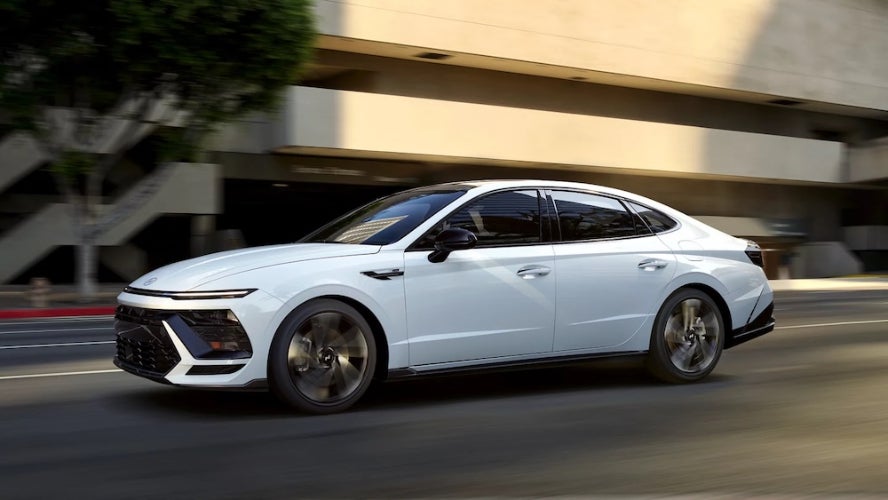 A white 2026 Hyundai Sonata sedan driving down a city street