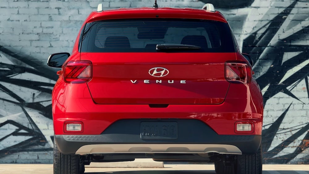 A red 2026 Hyundai Venue SUV parked in front of a mural