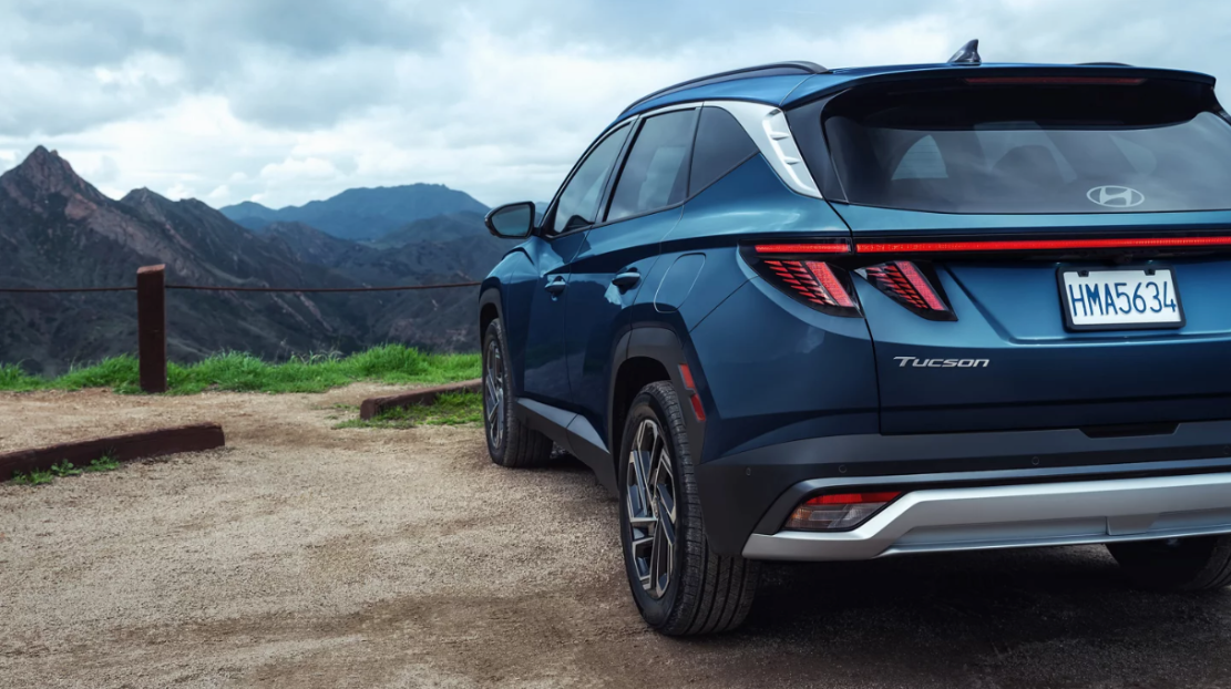 Rear view of a blue Hyundai Tucson overlooking a mountain