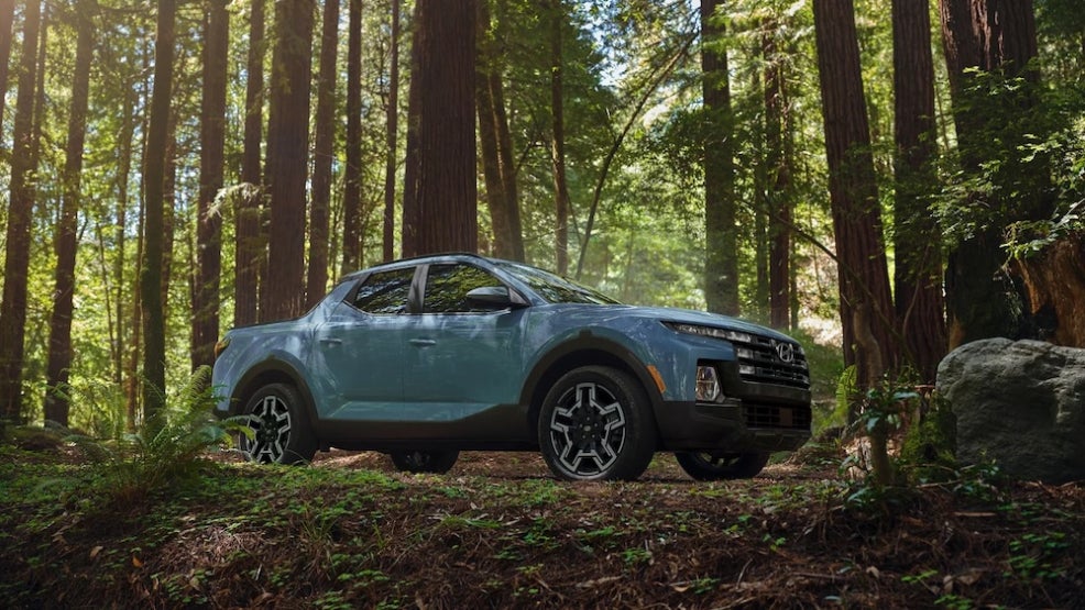 A light blue 2026 Hyundai Santa Cruz parked on a wooded trail