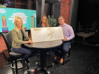 staff holding donation check