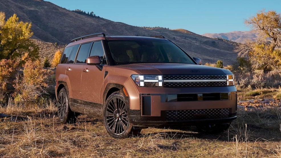 A brown 2026 Hyundai Santa Fe SUV parked at the base of a mountain